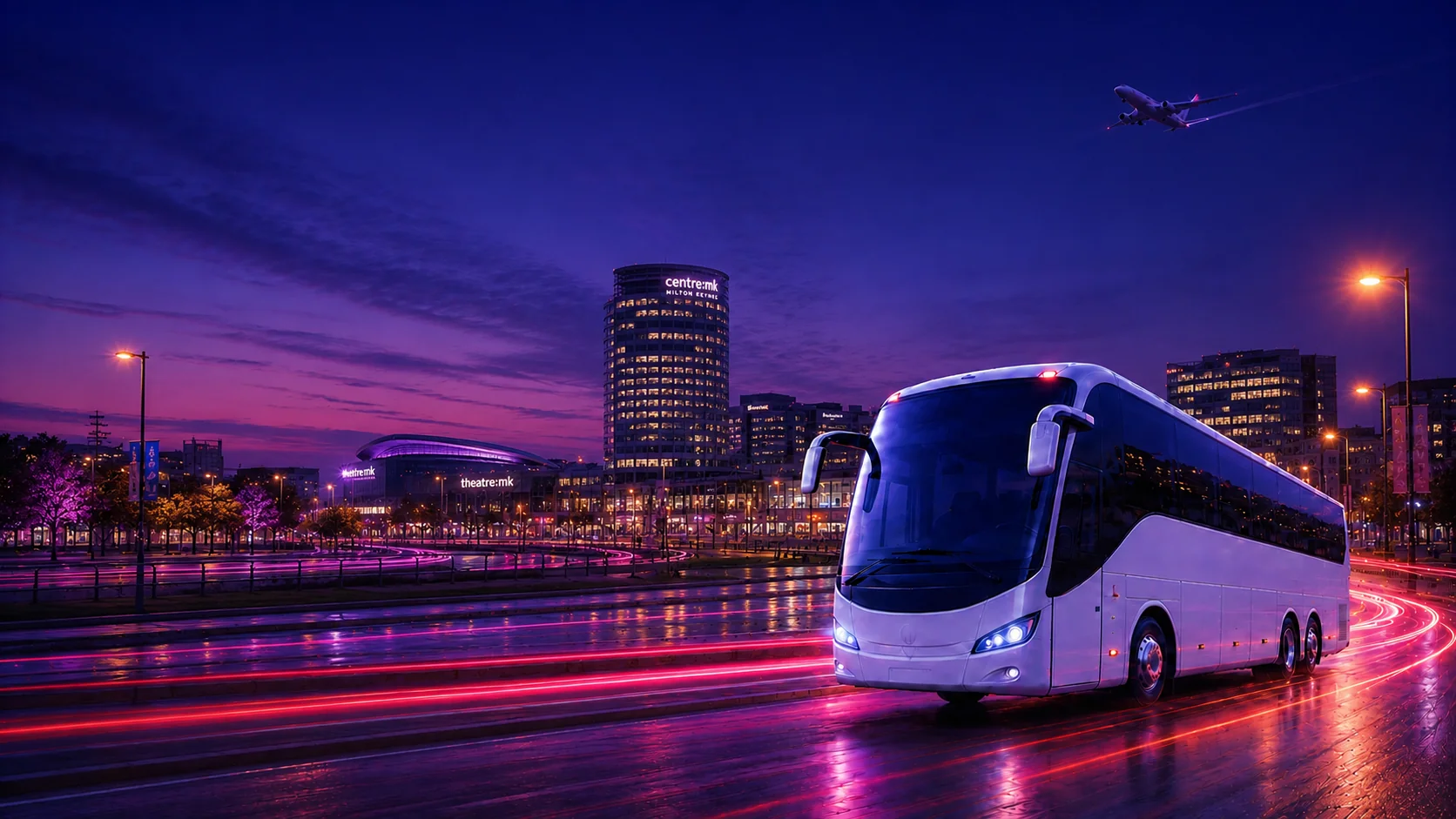 Airport Bus Express coach on a Milton Keynes road at dusk with the city skyline and a departing plane